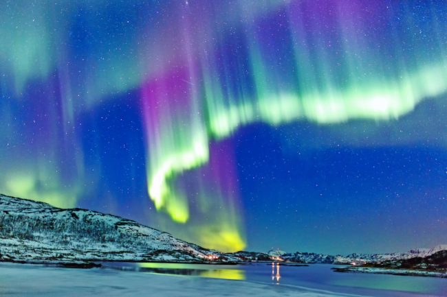 Incredible Northern lights Aurora Borealis activity above the coast in Norway