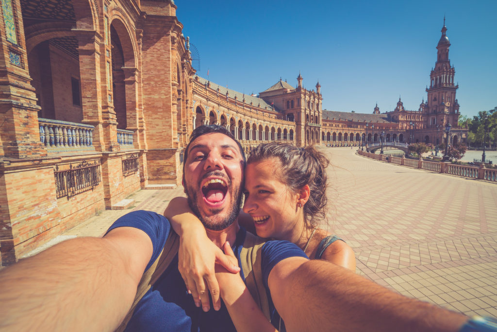 happy smiling couple take photo selfie in Spain square (plaza de