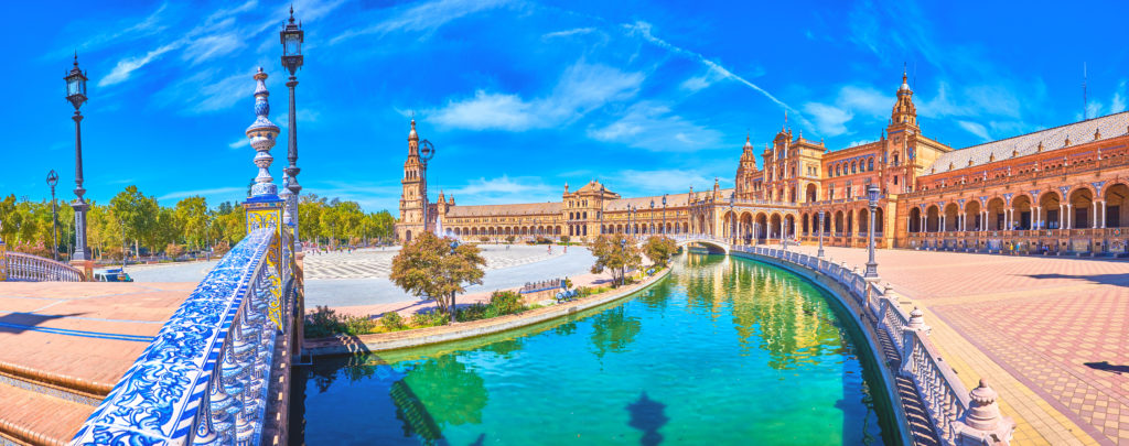 SEVILLE, SPAIN - OCTOBER 1, 2019: The view on Plaza de Espana with its canal leading along brick gallery and has bridges with beautiful ceramic handrails in Andalusian style, on October 1 in Seville